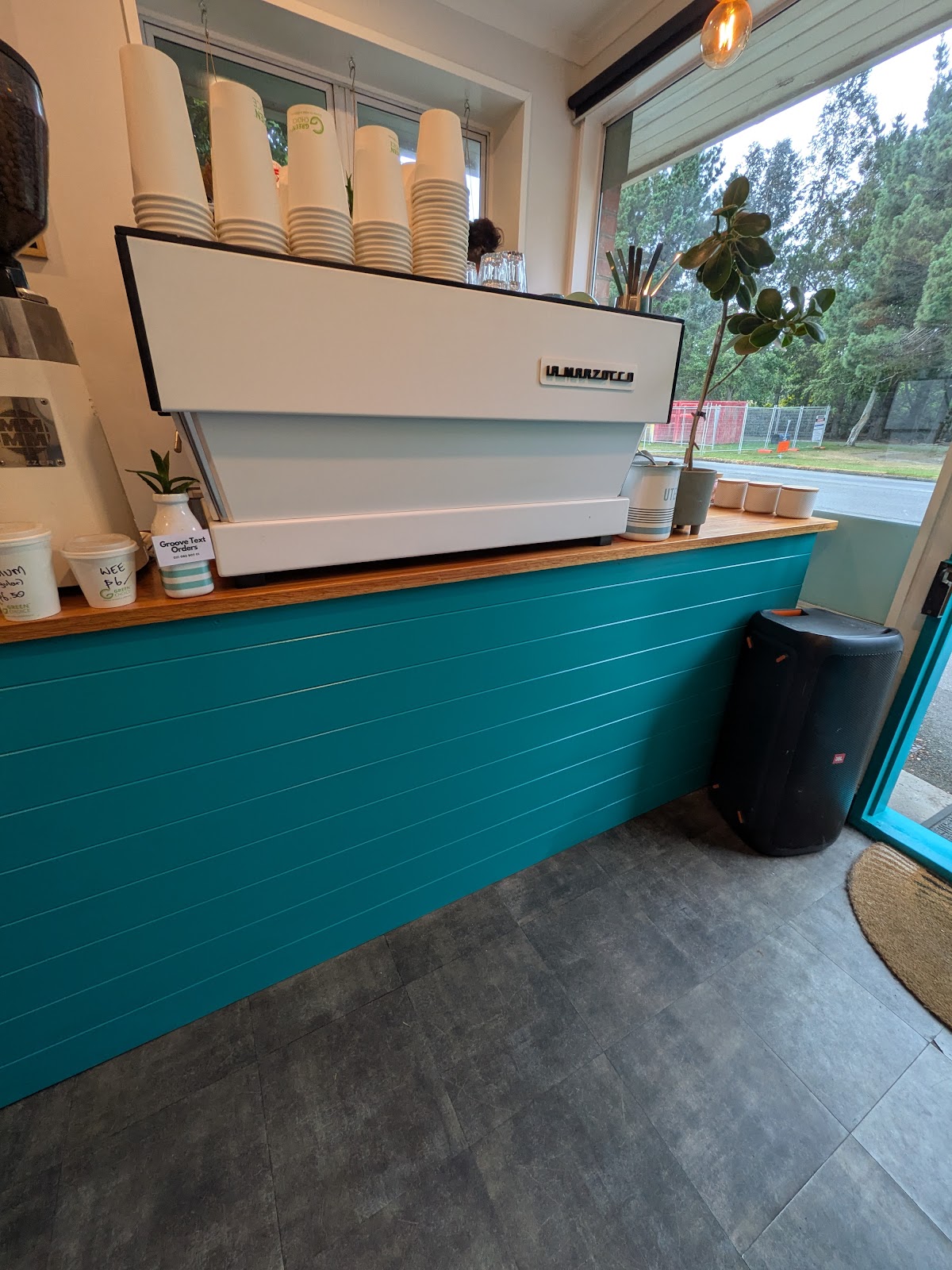 The teal counter and espresso machine inside Groove Espresso