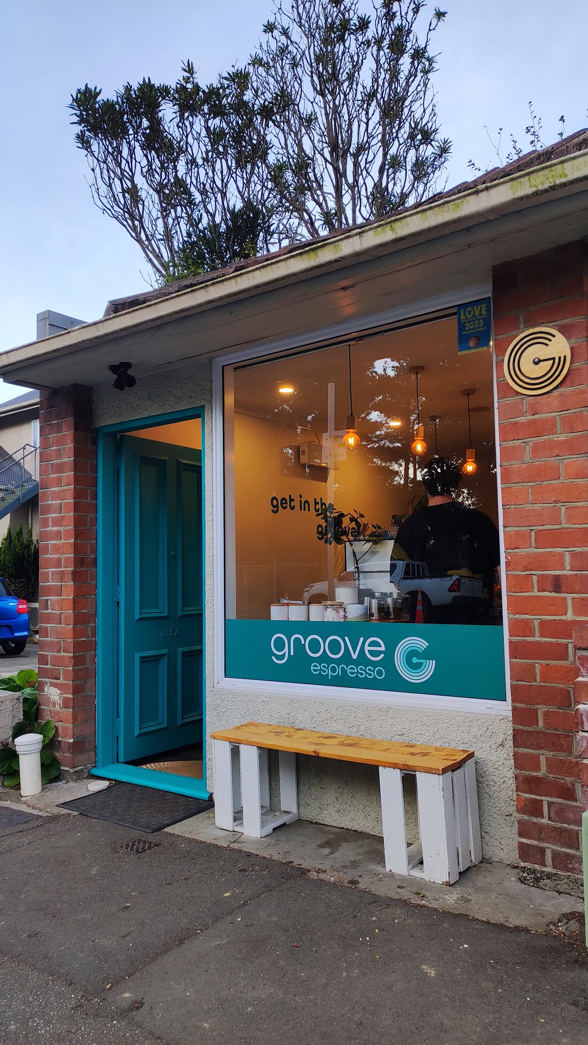 Groove Espresso shopfront at dusk with the get in the groove wall